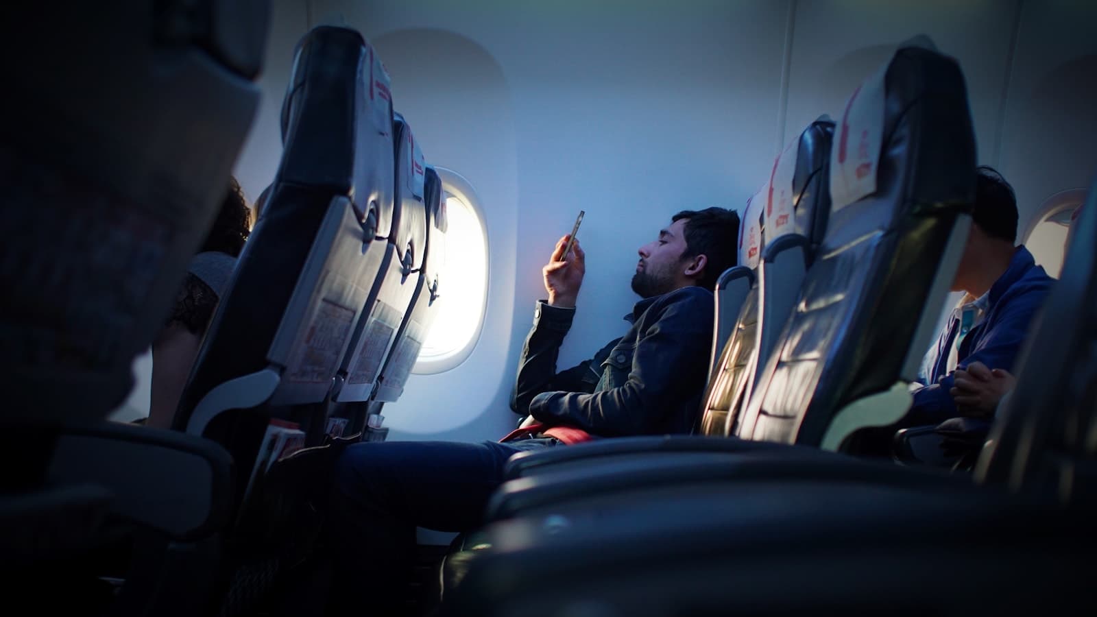 Reiziger gebruikt een smartphone tijdens een vlucht.